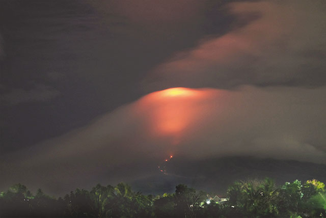 PALL OF GLOOM – Mayon Volcano's crater is aglow, though barely luminous through the thick clouds that engulfed the Bicol region Sunday, in this photo taken from Daraga, Albay, and obtained from a social media post of Romulo Quinto Ceneta. (Reuters)